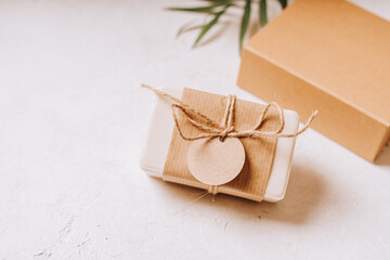 Soap in Craft eco Gift box or present box with bow on white background with mockup label tag. Copy space for text and design. Package, zero waste, plastic free, eco friendly concept.