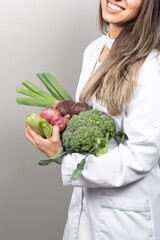 Smiling female nutritionist in her office,  showing healthy vegetables and fruits. Healthcare and diet concept. Lifestyle.