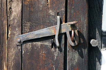 Ancient door latch on old wooden door.
