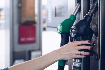 Gasoline and diesel distributor at the gas station. Blonde woman is going to refuel the car.