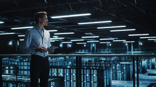 Data Center Engineer Using Digital Tablet Computer, Maintenance Specialist. High-Tech Information Protection, Cyber Security. Cloud Computing Facility. Server Farm for Iaas, saas, paas. Medium Wide