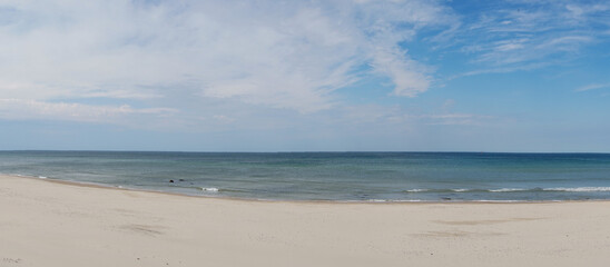 panorama view of amazing white sand beach and calm ocean under an expressive sky