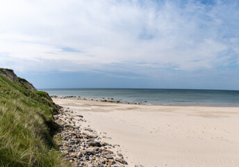 beautiful white sand beach with high grassy sand dunes behind