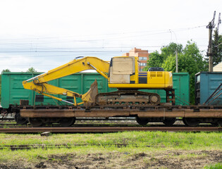 Fototapeta na wymiar Railway. Railway repair site with..Excavator, special repair train with a tractor. Transportation of bulky equipment