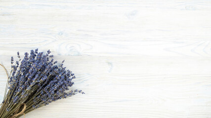 Dry lavender flowers bouquet on a wooden background with space for text. Top view<er
