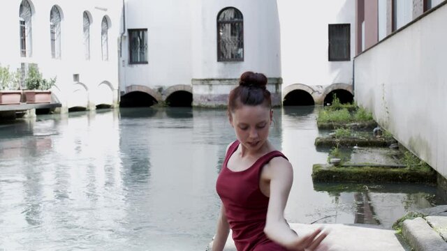 Ballet dancer sitting by the city river. farography, dancing