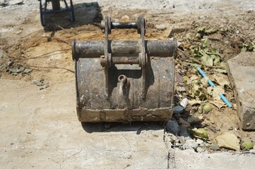 A bucket of a excavator take off placed on the cement floor.