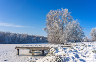Winterlandschaft in Norddeutschland, Schnee und Eis in Bremerhaven, gefrorene Oberfläche vom Auesee, Sonnenschein im Winter, Naturschutzgebiet