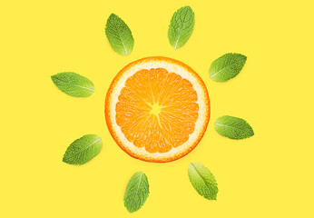 orange slice and mint leaves on a yellow background. summer concept