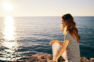 Fototapeta na wymiar woman in t-shirt and trousers portrait sea sunset sun