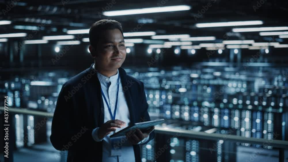 Aufkleber Handsome Smiling IT Specialist Using Tablet Computer in Data Center. Succesful Businessman and e-Business Entrepreneur Overlooking Server Farm Cloud Computing Facility. Medium Wide Shot