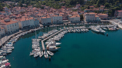 Aerial view of boats moored in the tartini square in piran, different boats resting on the edge of Piran marina.