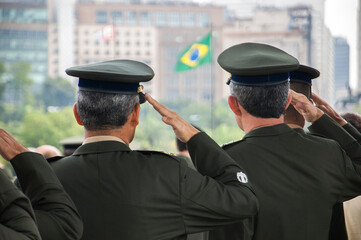 Officials from the Brazilian army saluting for the Brazilian flag