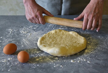 Homemade dough. Kneading with the hands of dough for making bread and buns at home. Men's hands kneaded dough for bread and muffins homemade.