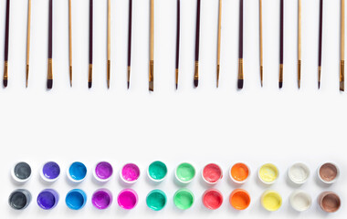 Paints and brushes for painting on white  paper background.