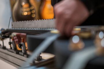 Black electrical guitar in repair service shop with a hands of a guitar luthier