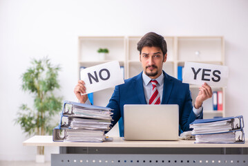 Young male employee unhappy with excessive work in the office