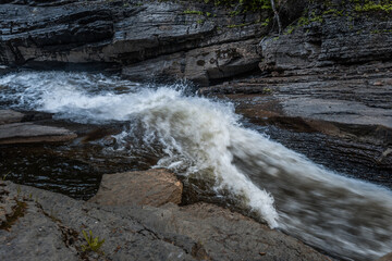 amazing photo of a nordic waterfall during a summer sunrise in Quebec, Canada