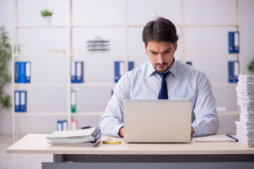 Young businessman employee unhappy with excessive work in the of