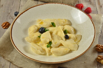 Lazy dumplings of cottage cheese with sour cream and berries