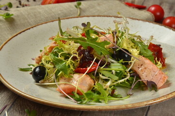 Warm Salad with Grilled Salmon and Vegetables on rustic table
