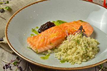Grilled salmon with garnish on wooden table