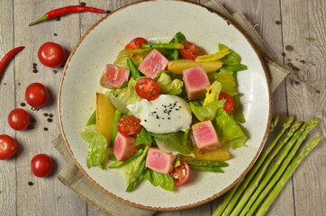 fresh tuna Nicoise fish salad with vegetables and avocado on wooden background