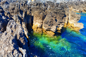 Coastal rock formation and ocean turquoise water . Tropical littoral . Oceanfront cliffs of Boca do Inferno