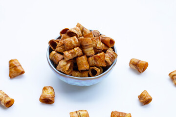 Dried banana rolled chips on white.