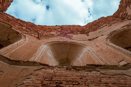 A view from below of a cloudy sky, from inside an old abandoned church. A brick wall with a windows. Smolensk region, 1753.