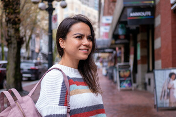 カナダの街中でリュックサックを持って散策するメキシコ人女性