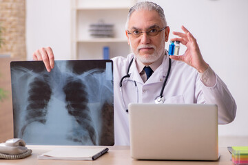 Old male doctor radiologist working in the clinic