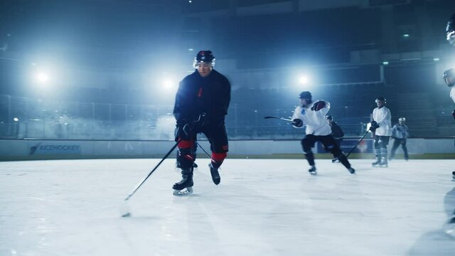 Ice Hockey Rink Arena: Professional Forward Player Masterfully Dribbles, Breaks Defense, Hitting Puck with Stick Scores Goal, Goalie Missed it. Team Celebrates Victory. Cinematic Slow Motion Wide Shot