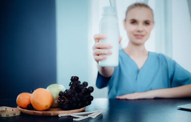 Nutritionist Female Doctor is Showing a Glass of Milk to Camera, Vitamin Nutrients From Vegetables for Healthy Eating. Female Doctor is Consulting and Advise to Patient About Nutrition for Health.