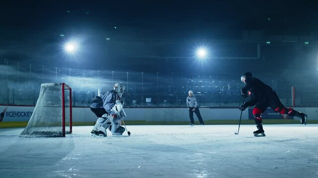 Ice Hockey Rink Arena: Professional Forward Player Masterfully Dribbles, Hitting Puck with Stick Scores Goal, Goalie Missed it. Forwarder againstGoalkeeper One on One. Cinematic Slow Motion Wide Shot