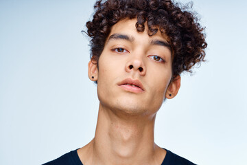 Obraz premium cute guy curly hair black t-shirt close-up model