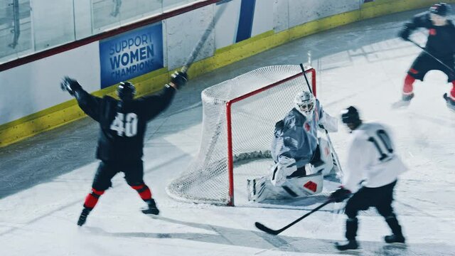 Ice Hockey Rink Arena: Professional Forward Player Masterfully Dribbles, Breaks Defense, Hitting Puck with Stick Scores Goal, Goalie Missed it. Fast, Energetic, Cinematic High Angle Wide Shot