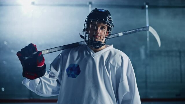 Ice Hockey Rink Arena: Portrait of Confident Professional Player, Wearing Wire Cage Face Mask, Looking at Camera and Smiling. Focused Athlete, Determined to Win and become Champion. Medium Shot