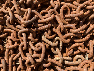 Close up of an old rusted and piled up iron chain.