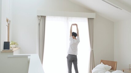 寝室でストレッチをする男性