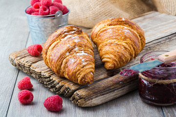 Fresh croissants with raspberry jam close-up.