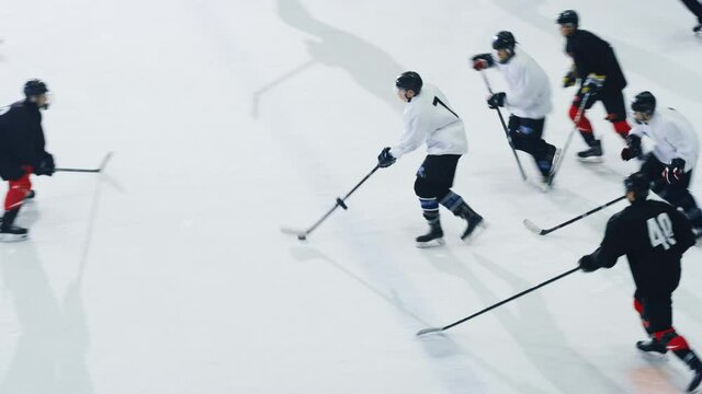 Ice Hockey Rink Arena Game Start: Two Players Brutal Face off, Referee Drops the Puck, Leading with Masterful Dribble Player Scores Goal when Goalie Misses the Puck. Aerial Drone High Angle Shot