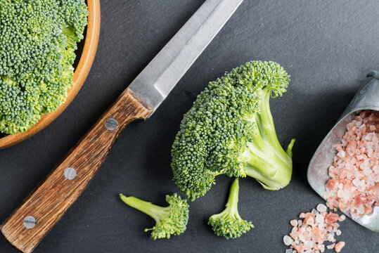 Fresh broccoli with knife on bleck table