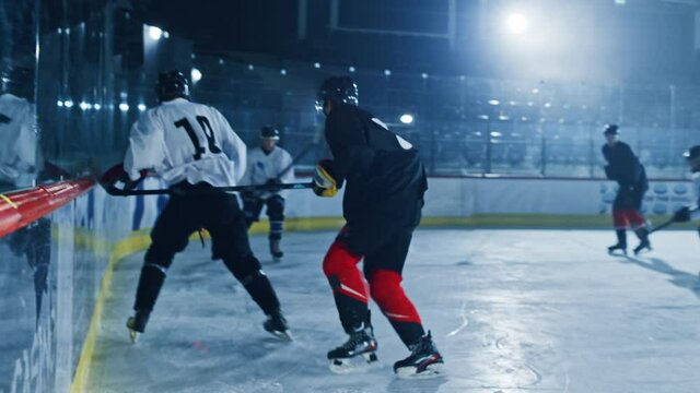Ice Hockey Rink Arena: Professional Defender Player Attacks, Boarding Attacker Aggressively, Taking away the Puck. Competitive Intense Game with Amazing Skills, Speed, Energy, Power. Fast Slow Motion