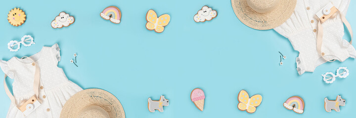 Summer banner made with white dress, the straw hat, sunglasses and funny gingerbread on blue background. Fashion girl lookbook concept. Top view Flat lay Copy space