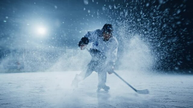 Ice Hockey Rink Arena: Professional Player Shooting, Hitting, Stricking the Puck with Hockey Sticks. Athlete Scoring a Goal. Dramatic Mock-up. Wide Shot, Cinematic Lighting, Slow Motion