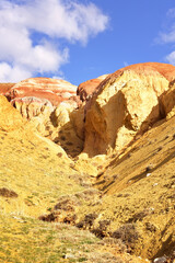 Fototapeta premium Mars in the Altai Mountains. The slope of the river terrace with the exposure of colorful clays and siltstones under the blue sky is a geological attraction. Chui Valley, Siberia, Russia