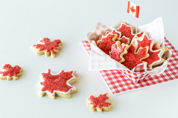 A checkered tray filled with Canada flag sugar cookies for Canada Day.