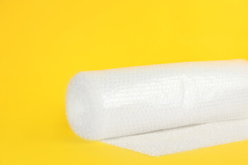 Bubble wrap roll on yellow background, space for text