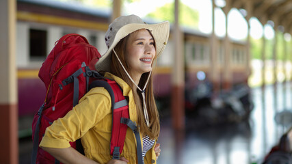 Side view of friendly female backpacker smiling when arriving at terminal
